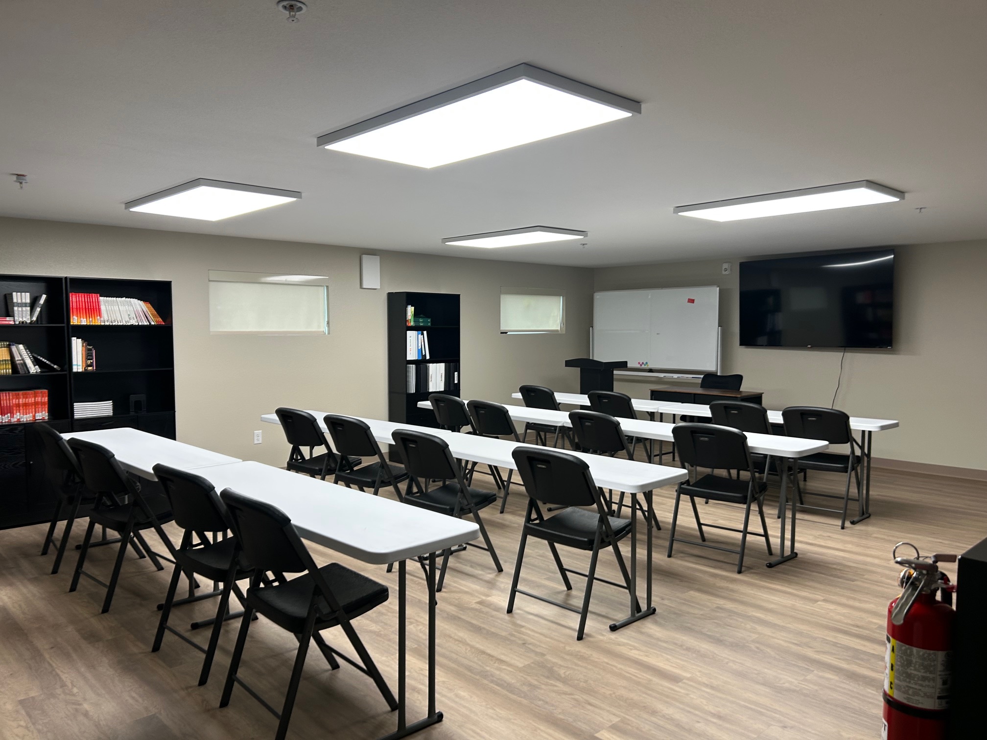 Classroom with Tables, Chairs, Whiteboard, and TV