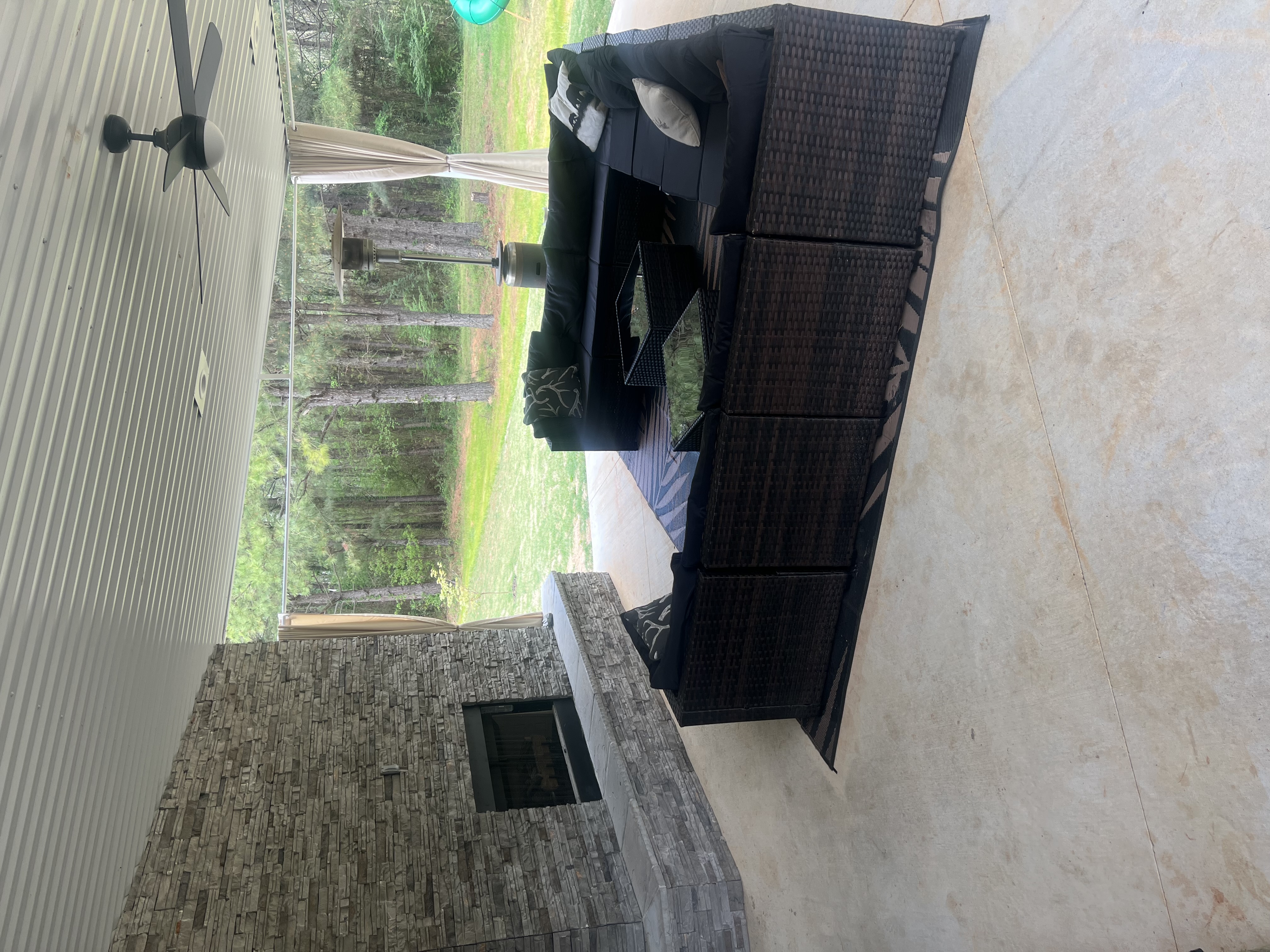 Covered Outdoor Patio with Stone Fireplace and Wicker Seating